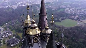 Bird's-eye view: Majestic sky castle hovers above landscape. Camera orbits around ornate spires, revealing intricate gears and massive engines.
