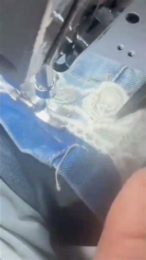 sewing a delicate white lace fabric using a professional machine for beautiful clothing designs