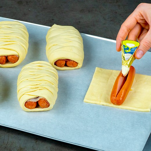A little trick and sausages in puff pastry turn into a masterpiece! Ingredients: puff pastry: 400 g (14 oz) sausages: 500 g (18 oz) processed cheese: 100 g (3.5 oz) bacon: 120 g (4.2 oz) eggs: 1 pc Greek yogurt: 100 g (3.5 oz) ketchup: 50 g (1.8 oz) vinegar: 7 ml (0.2 fl oz) pickled cucumbers: 20 g (0.7 oz) salt: 4 g (0.1 oz) black pepper: 2 g (0.1 oz) | Appetizing.tv