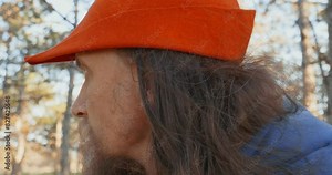 Portrait of a man with a beard in a medieval costume looking around in the forest. Close up. Reconstruction of historical events