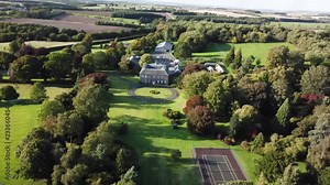 Aerial England landscape Manor house farm. Wealthy rich estate, tree lined entrance. Lush green landscape countryside in the UK and England. Forest, rock and hedge rows divide fields.