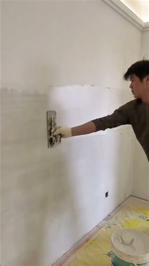 Skilled worker smoothing interior wall plaster for flawless finish