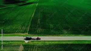 Red semi truck with RGN trailer, loaded with oversize load machinery in Indiana, USA. Aerial view. Stock Video