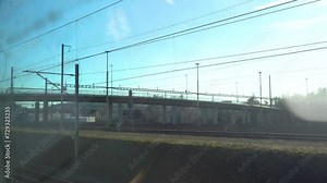 Train tracks and powerlines seen from a driving train