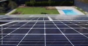 Slider shot: Solar panels on the roof of the house, below you can see the pool and green lawn.