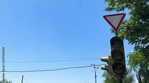 A broken traffic light. A yellow light is on at a traffic light. The light is on the corner of a street Stock Video