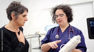 Video of a doctor explains to a woman how a portable emergency defibrillator works