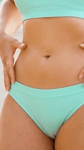 Woman checking her fitness and skin elasticity on stomach and sides