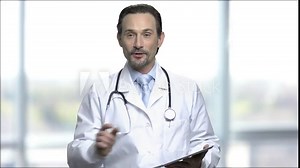 Mature doctor speaker using digital tablet. Caucasian male doctor using computer tablet during healthcare conference. Blurred window background. Stock Video