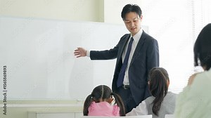 教室で子供たちに授業する男性教師