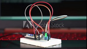 Using notebook computer to upload program to the microcontroller on the experimental board to study the IoT Internet of Things project.