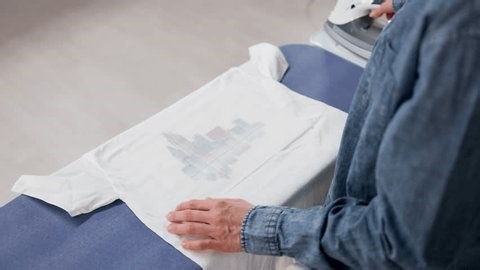 clip-4032875937-woman-using-iron-on-heat-transfer-apply-custom