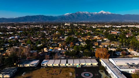 Urban neighborhood surrounded by trees with clear mountain backdrop