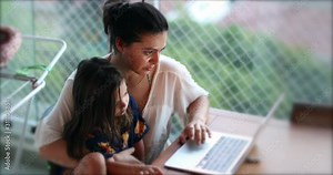 Mother and daughter child in front of computer screen. Parent and kid using technology together, browsing the internet