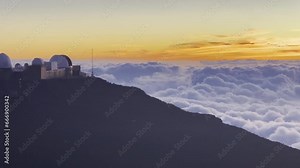 Cinematic panning shot from the Haleakala Observatory to the rolling clouds below the summit of Haleakala at sunset in Maui, Hawai'i. 4K HDR at 30 FPS