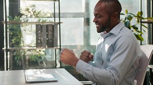 African American business man businessman winner with laptop winning dancing moving manager employer celebrate victory win online bet on computer finance growth at office yes gesture dance sunny light