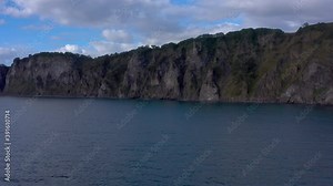 Inaccessible rocks of the Avacha Bay. The harsh nature of Kamchatka. Majestic cliffs, hills and mountains. Seascape. Travel to the Kamchatka Peninsula.