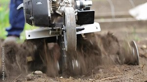 Man farmer working in field ploughing the land with a plough on a farm. Ploughman on a walk behind motor cultivator. Season processing soil in village. Organic cultivate natural products. Agriculture