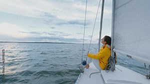 Lonely Woman relax on floating yacht. Alone caucasian beautiful girl sitting on the yacht deck and looking at horizon. Travel concept, holiday, sea waves and sailing