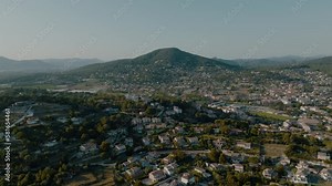 Carqueiranne, Var, Provence-Alpes-Côte d'Azur, France; calm relaxed rotating aerial over suburbs houses; beautiful sunny summer day; outer town on forest hills; clear skies, green trees