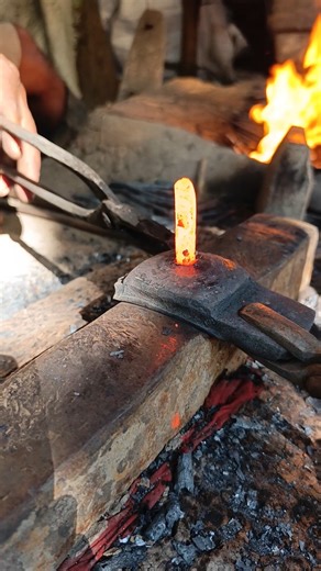 Watch how a skilled blacksmith hand-forges nails from old iron by hammering it into shape."