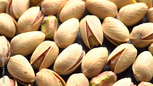 Close up of Roasted Pistachios in Shells with Green Kernels Visible