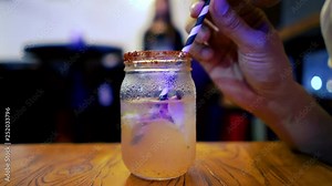 Timelapse of drinking a drink at a restaurant. Time lapse of finishing a whole cocktail at a bar. Drinking entire alcoholic beverage fast from mason jar with paper straw.