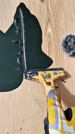 Using A Paint Scraper To Carefully Remove A Layer Of Dark Paint From A Wooden Surface