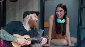 Multicultural couples in relationship spend time together, friends holiday vacation backpacker lifestyles concept, happy Asian girl and Caucasian man stay in bunk bed bedroom sharing low-cost hostel