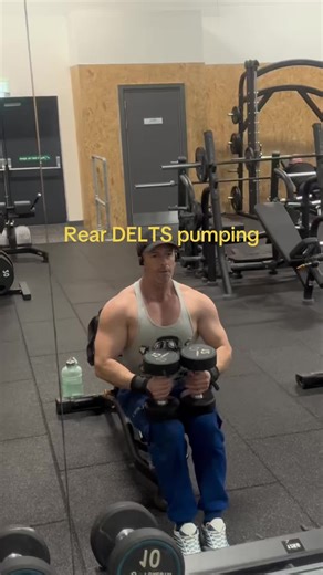 Hitting the gym hard with these dumbbell rear flys – focusing on that rear delt pump and shoulder definition for the ultimate men’s physique vibe! Gray tank, black cap, wrist wraps locked in, and earbuds blasting my playlist. Seated on the bench, form on point, water bottle ready for the hydrate break. No excuses, just gains. Who’s joining the grind today? 💪🔥 #fyy #workoutmotivation #gymlife #mensphysique #gymtok