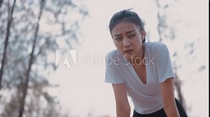 Beautiful asian woman athlete running resting exhausted after a cardio workout exercise in the outdoor sunset. Jogging lifestyle healthy. tired girl runner resting in a park