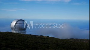 Observatory on La Palma. Gran Telescopio Canarias with time lapse clouds behind