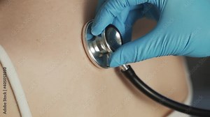 Close-up of doctor hand using stethoscope with a female patient, checking the lungs and heart beat