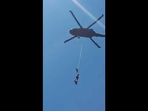 Army Rangers lifted up on rope by helicopter