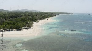 Tourists Swimming In Shallow Blue Sea At Playa Teco Maimon, A Touristic White Sand Beach In The Dominican Republic. aerial pullback