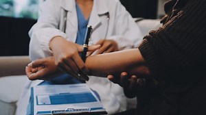 Download A doctor checking the arm of a patient for free