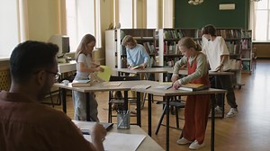 Students and teacher preparing for class in a school library | Free Stock Video Footage