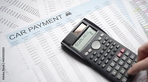 Calculating Car Payment With Calculator Over Finance Document