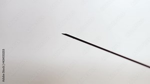 vaccination concept, dripping drops from the syringes needle close up. soft grey gradient background. horizontal slow motion macro HD video.