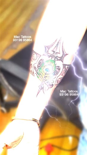 Original Mac Tattoos Hauz Khas on Instagram: "Power, faith, and devotion inked together 🔱 This custom Trishul tattoo with Mor Pankh and Damru represents the perfect balance of Shiva’s strength and Krishna’s divine grace. Clean lines, bold details, and deep meaning—crafted with precision for a timeless look. Every tattoo tells a story, and this one speaks of belief, energy, and inner power. Ink your faith. Wear your devotion. #TrishulTattoo #ShivaTattoo #KrishnaTattoo #MorPankhTattoo #DamruTatto