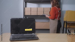 A laptop displays an AI chatbot regarding the status of an order shipment, with an Asian woman managing inventory in her small home business