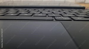 Laptop keyboard or tablet PC keyboard close up, camera moving from right to left.