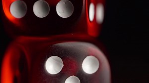 Red dices on black background. Red dice standing on each other, macro on black background