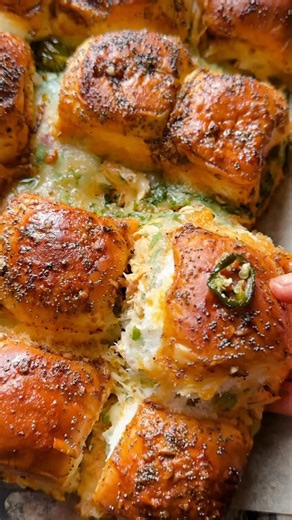 Tieghan Gerard on Instagram: "Easy pull-apart Buffalo Chicken Dip Sliders - everyone is obsessed 🤍 So cheesy on the inside, golden + toasted on the outside, and finished with a garlic butter topping you’ll want on everything. Perfect for game day—just make a double batch because they go FAST. Comment HBH for the recipe. 1 cup cooked shredded chicken ½ cup buffalo sauce 3 ounces cream cheese, at room temperature ½ cup fresh cilantro, chopped ¼ cup chopped scallions 1 package dinner rolls, halved