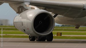 Heat shimmer behind jet engine and landing gear of taxiing airplane