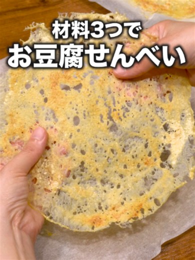 レンチンだけでできるんだ！「コンソメ豆腐チップス」#レンジで簡単#豆腐#おやつ#料理動画 #デリッシュキッチン 詳しくはデリッシュキッチンアプリで「コンソメ豆腐チップス」と検索🔍 ■材料 (2枚分) 絹豆腐(ミニパック) 1丁(150g) コンソメ 小さじ1/3 こしょう 少々 ■手順 (1)豆腐はキッチンペーパーで水気を拭き取る。ボウルに豆腐、コンソメ、こしょうを入れてなめらかになるまで泡立て器で混ぜる(生地)。 (2)耐熱皿にクッキングシートを敷き、生地を1/2量のせて薄く丸くのばす。(直径25cmの耐熱皿を使用しています。生地はクッキングシートが少し透ける程度を目安に薄く伸ばしましょう。) (3)ラップをせずに600Wのレンジで5分加熱する。一度取り出して庫内の水気を拭き取り、再度パリッとするまで600Wのレンジで1分30秒〜2分ほど加熱する。粗熱をとって余分な水分を飛ばす。残りも同様に計2枚作る。(お皿やレンジ庫内は熱いため、火傷に注意しましょう。2回目の加熱は全体の水分が飛んで少し黄色くなった状態を目安にし、短い時間から様子を見て加熱してください。粗熱をとってもパリッとしな