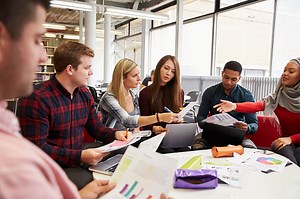 Group Of Students In Library Collaborating On Project