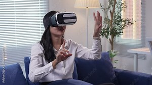 Woman wearing a virtual reality headset interacts with virtual objects, touching and manipulating them in an immersive environment