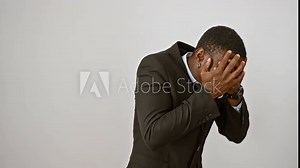 Embarrassed african american man in suit caught peeking, covering face with hand, eyes peeking through fingers with a shocked look, standing isolated on white.