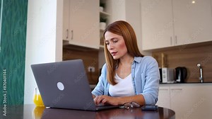 Woman using her computer at her dining table Stock Video